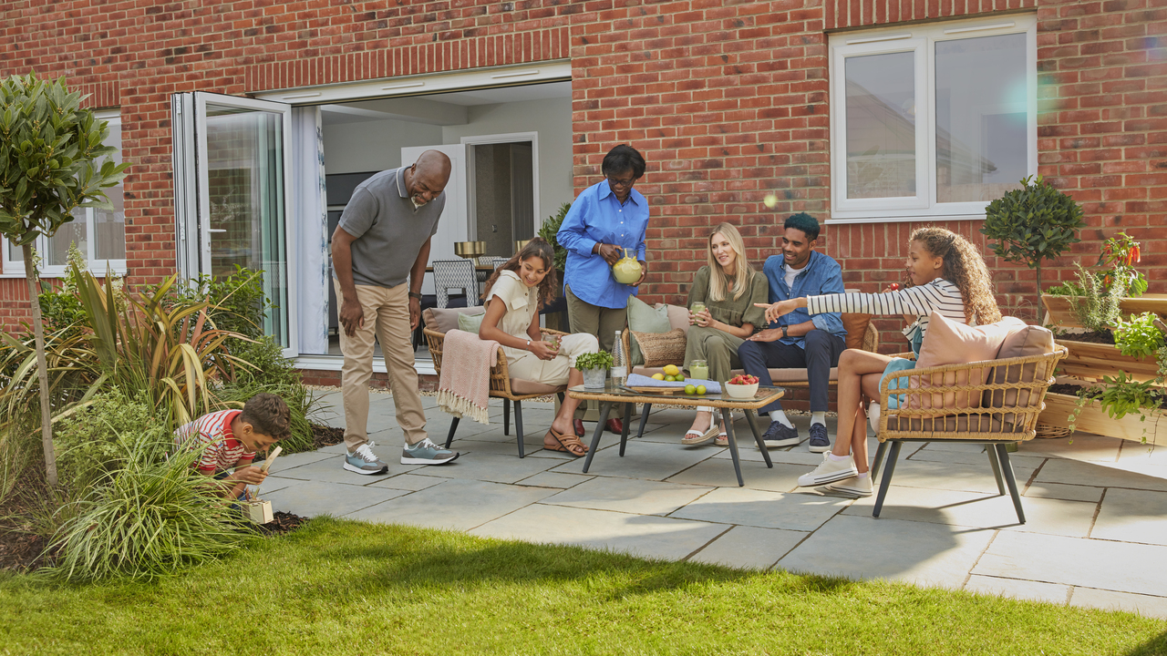 Family sat at a table in the garden on a sunny day