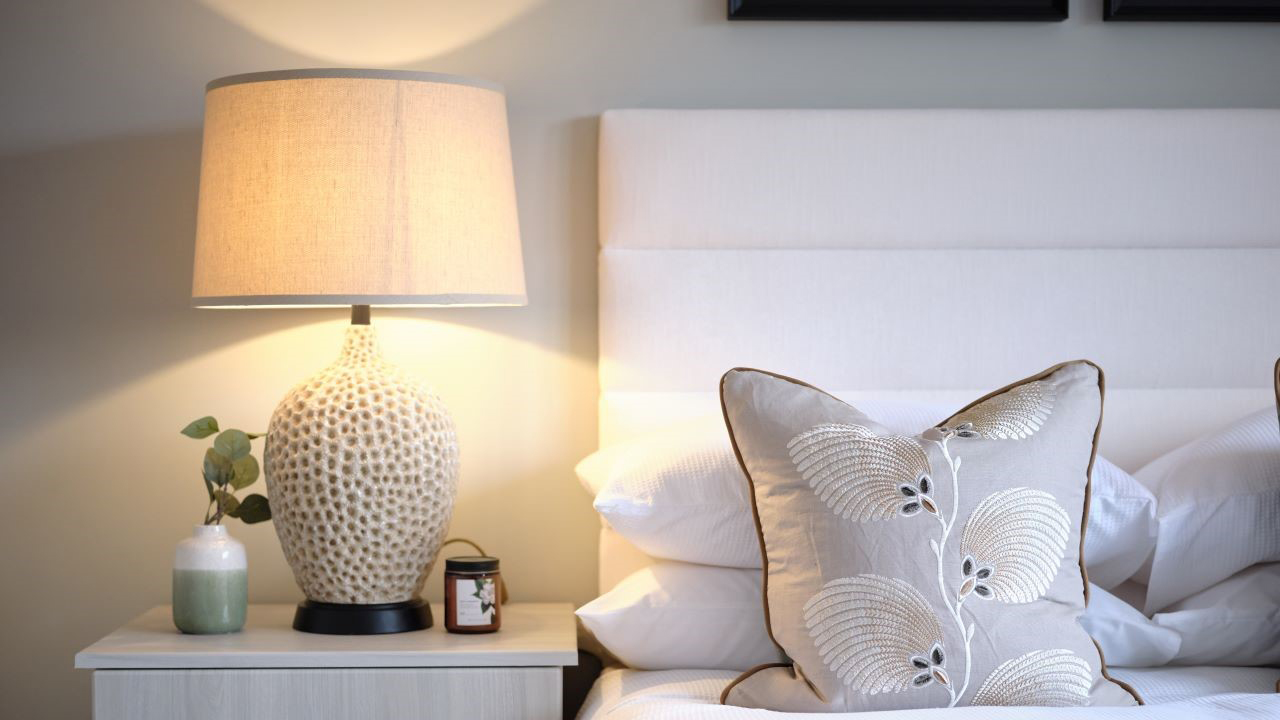 Bedsdie lamp in natural tones against a pale green wall