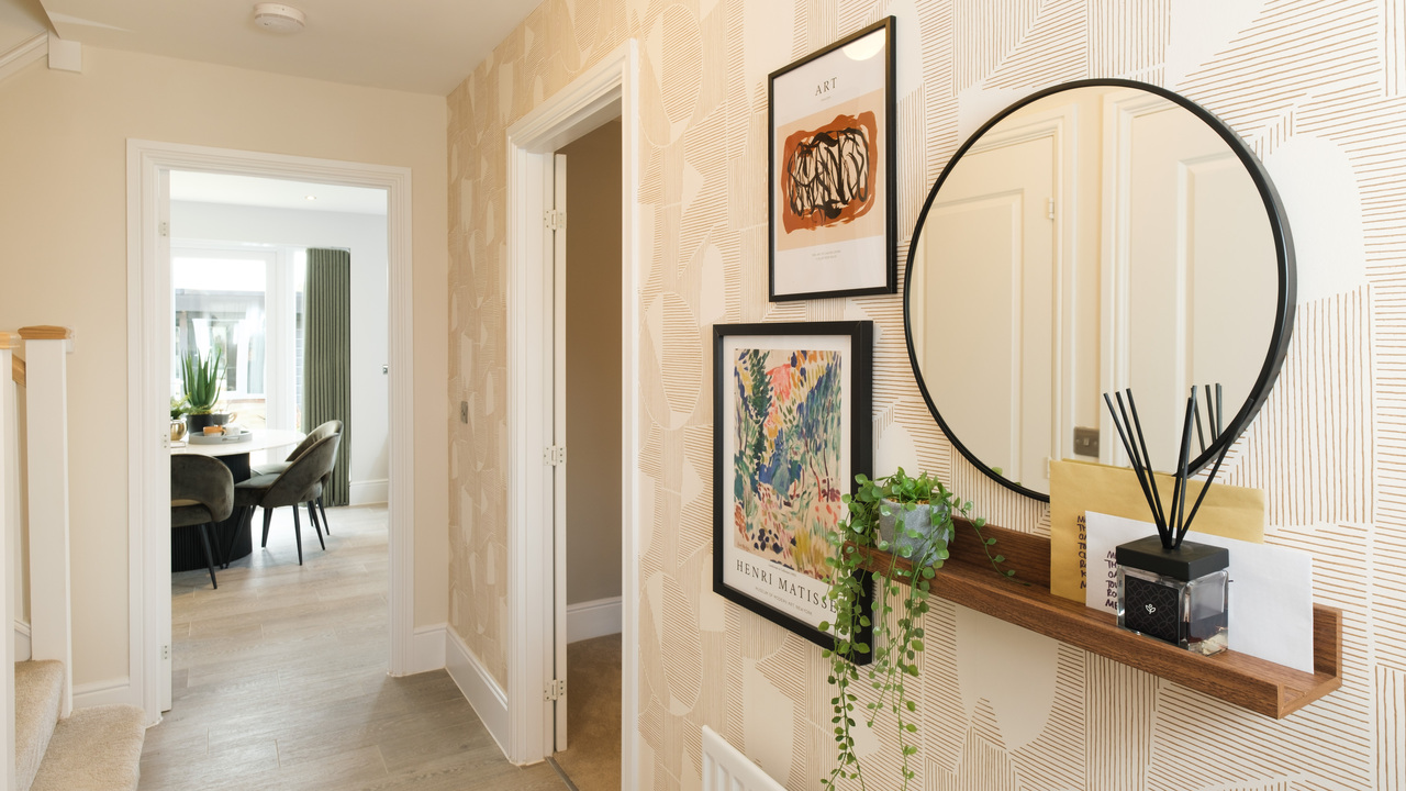 Wooden picture shelf and round mirror in a hallway