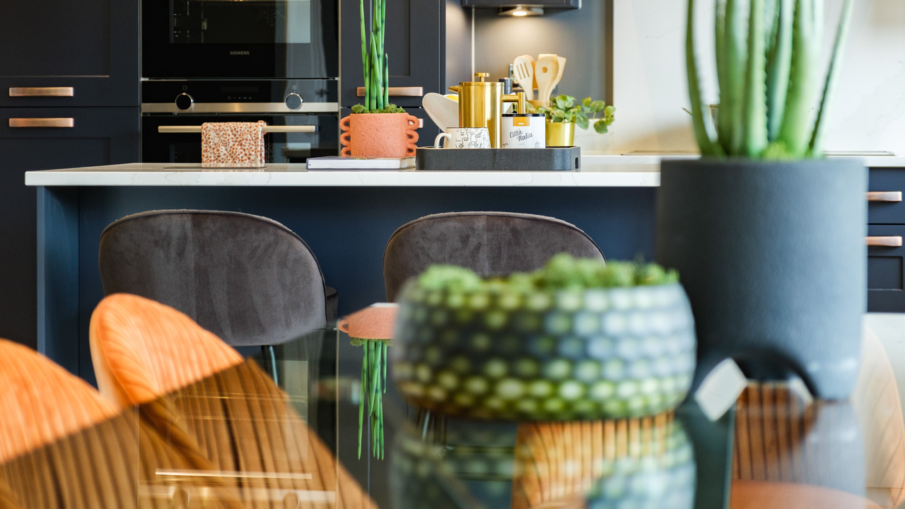 Glass-topped dining table with plants in textured pots