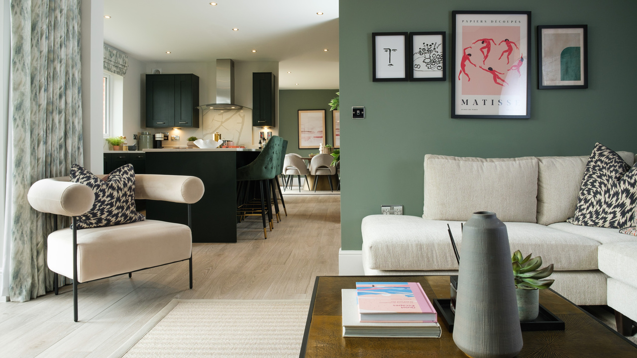 Open plan living space featuring dark kitchen units, a beige sofa and a stylish coffee table