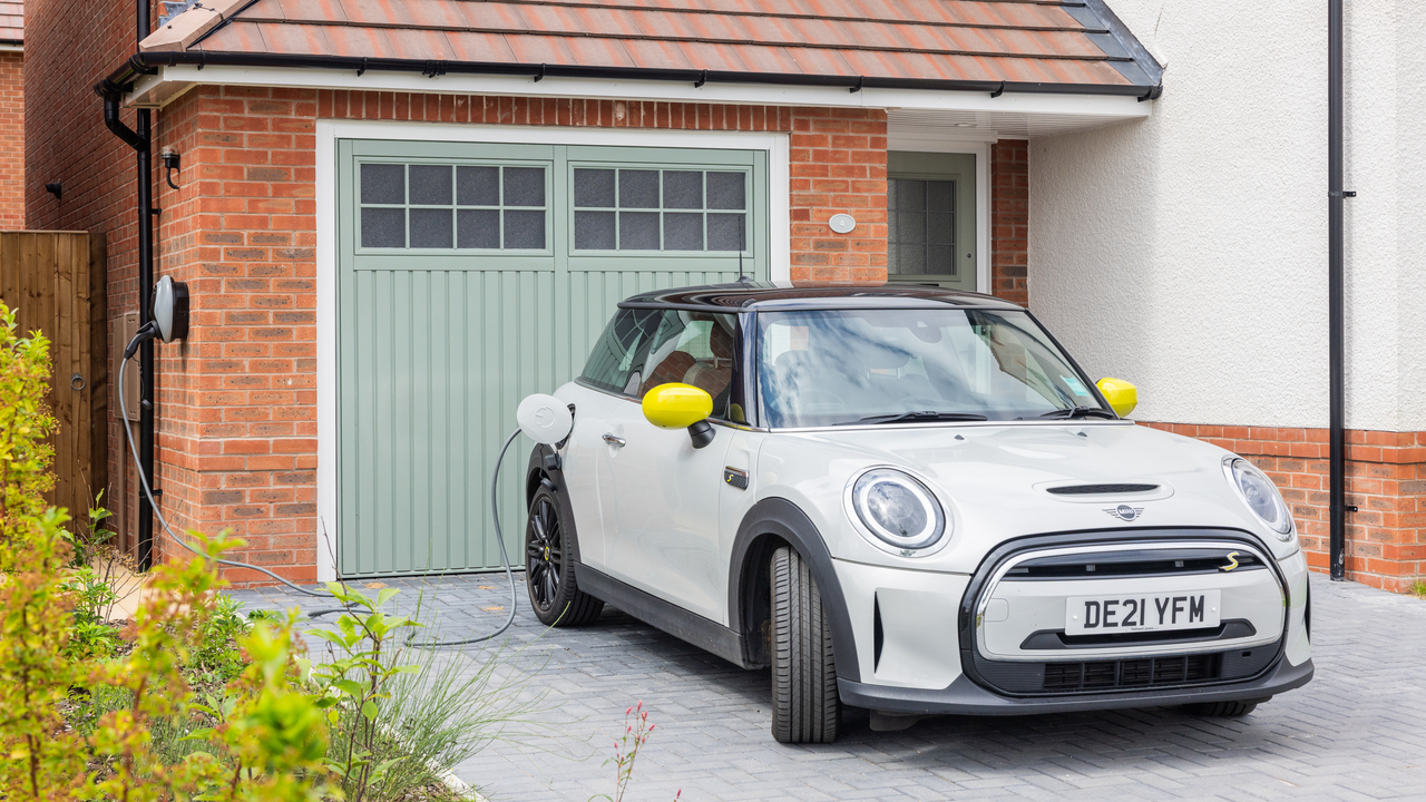 Electric car parked on the drive of a Redrow home, plugged into an EV charger