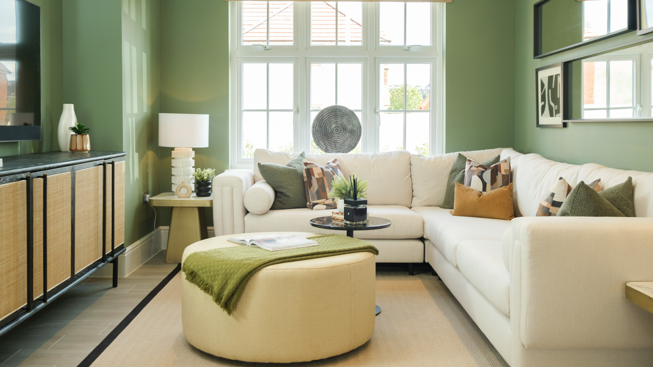 Stylish lounge with green walls and a white corner sofa