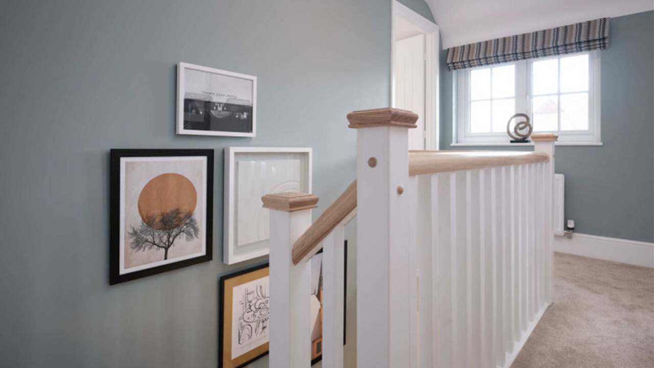 Upstairs landing with blue walls and four framed pictures