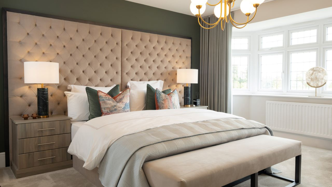 Main bedroom in muted colours, with a large, Chesterfield headboard over the bed