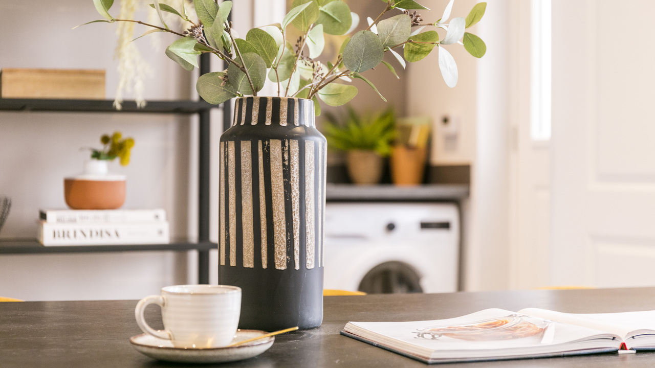 Striped ceramic vase and teacup and saucer on kitchen worktop