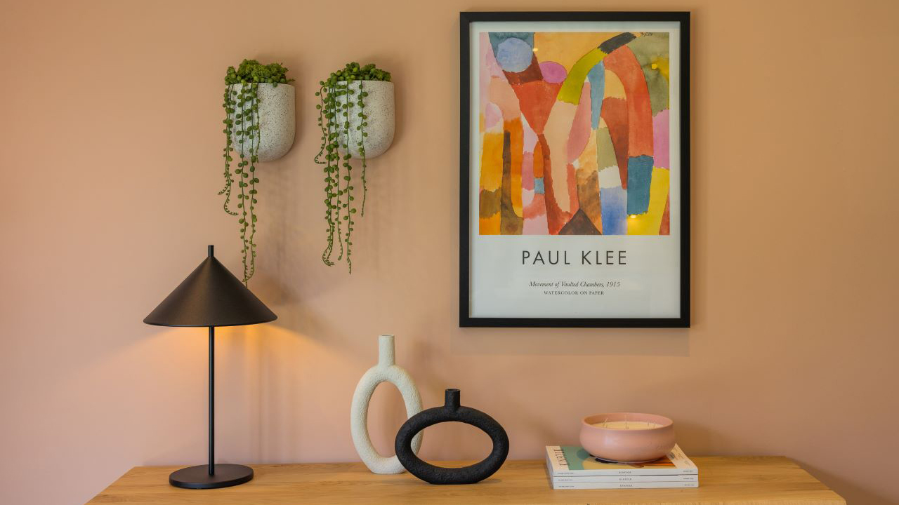 Abstract painting on peach wall and hanging plant pots