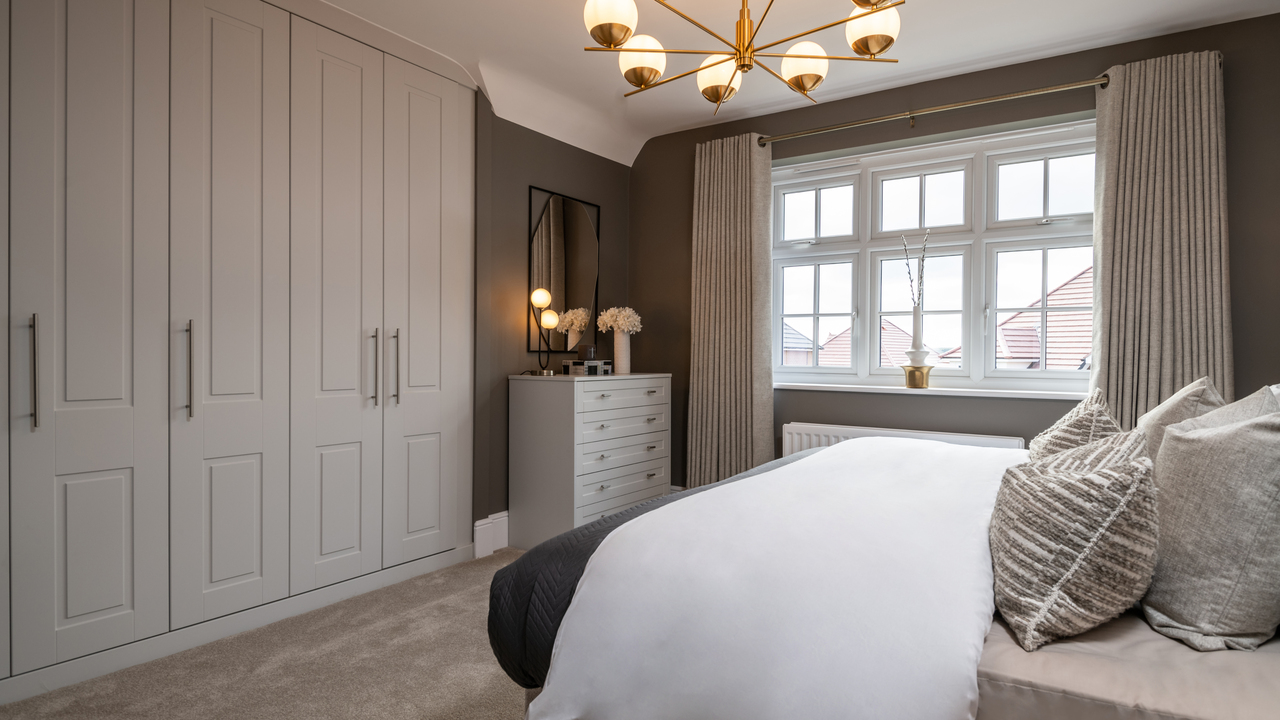 Bedroom with fitted wardrobe and white bed sheets