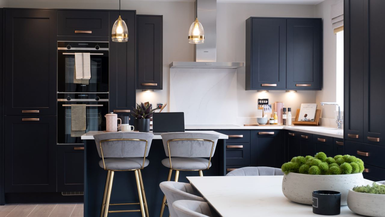 Kitchen with navy blue units and white, marble-effect worktops 