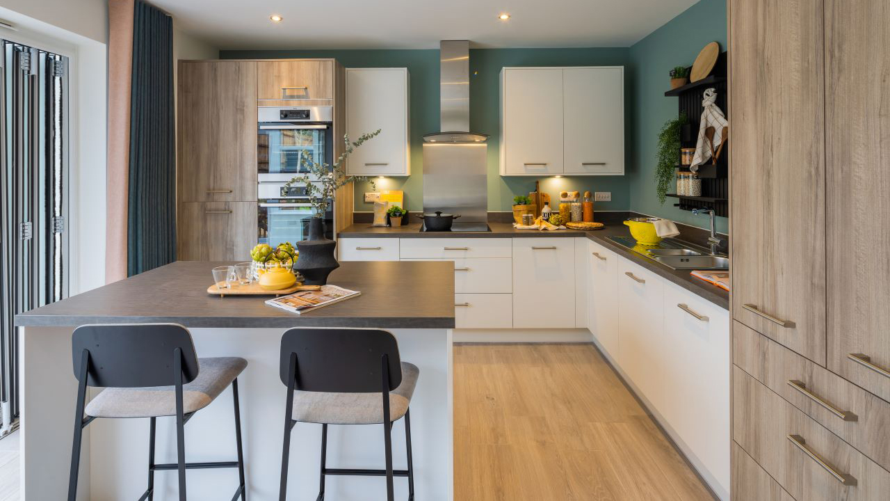 Kitchen with a mixture of white and dark ash units, plus a breakfast table with dark laminate top