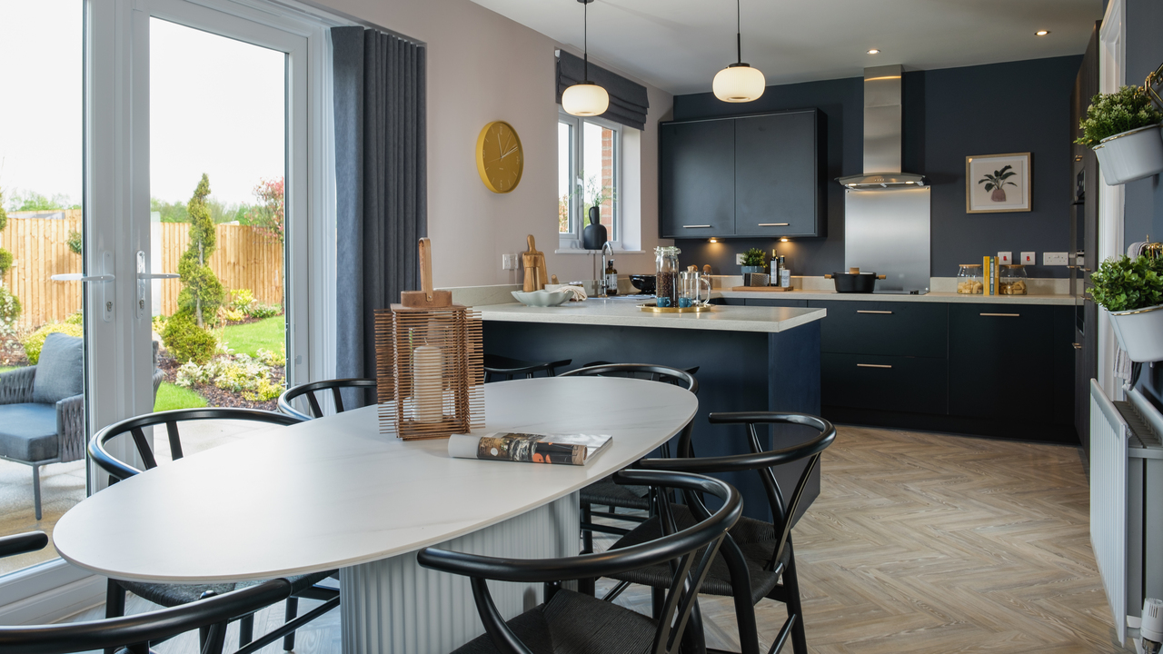 Kitchen and dining area with navy units and contrasting light wood flooring