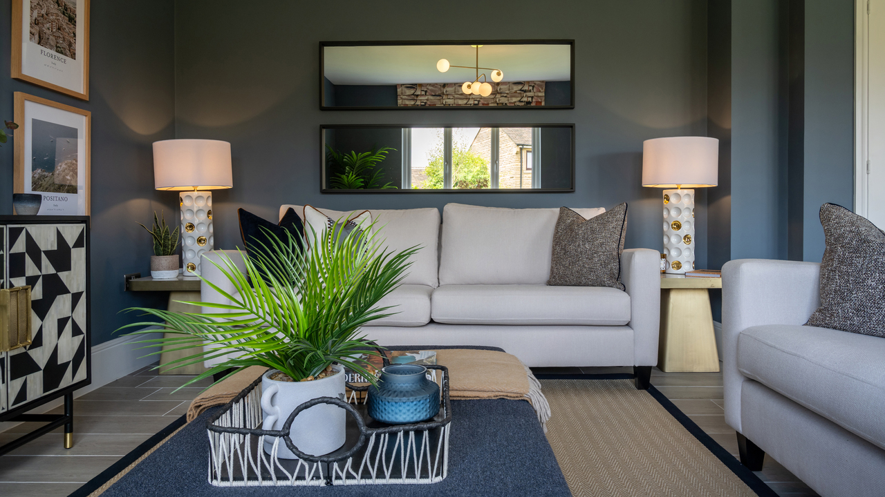 Stylish lounge featuring dark walls and two large lamps either side of a cream sofa