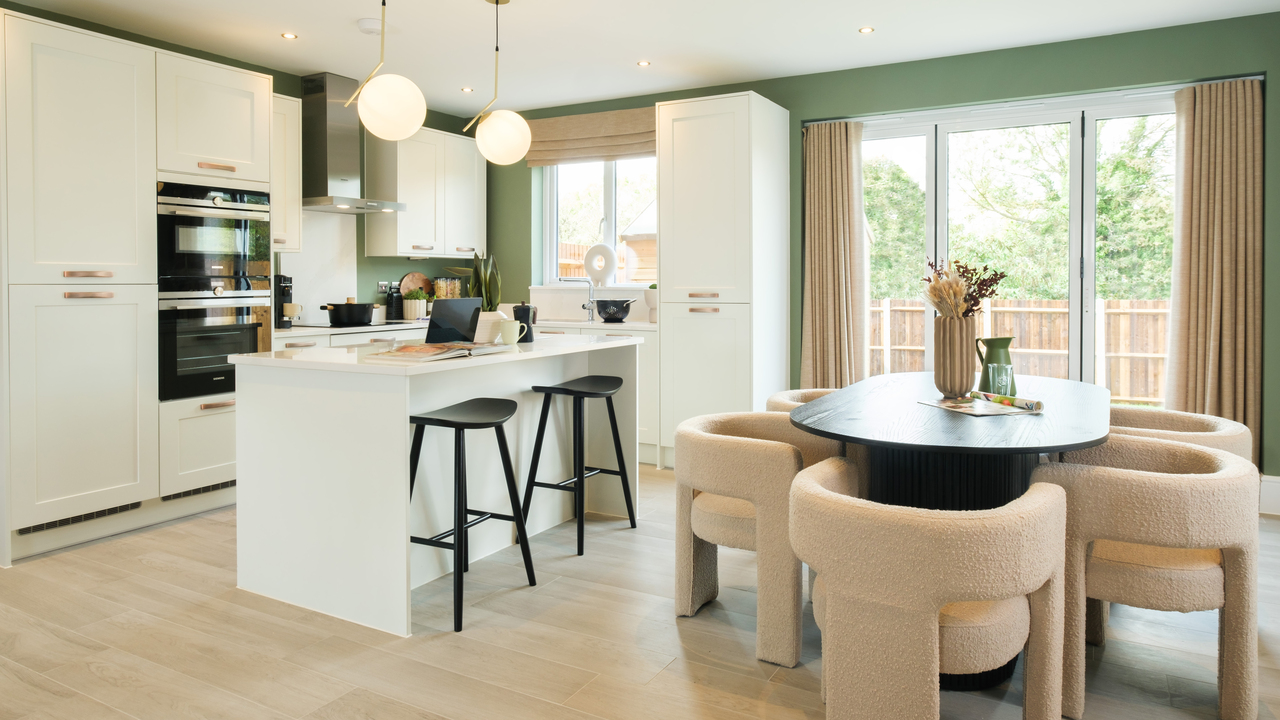 Open plan kitchen and dining area featuring a round dining table surrounded by shearling chairs