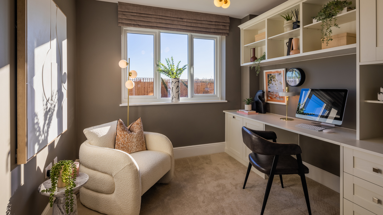 Home office with built in desk and storage and a stylish armchair