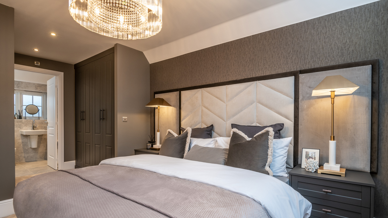 Grey bedroom with chandelier and feature headboard