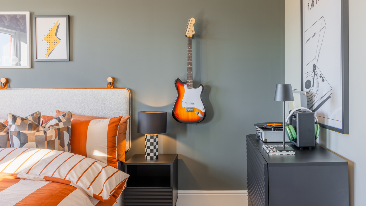 Bedroom with a guitar hanging on the wall and music-themed artworks