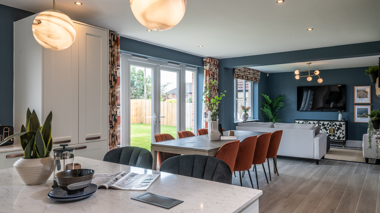 Open plan kitchen dining and family area with dark blue walls