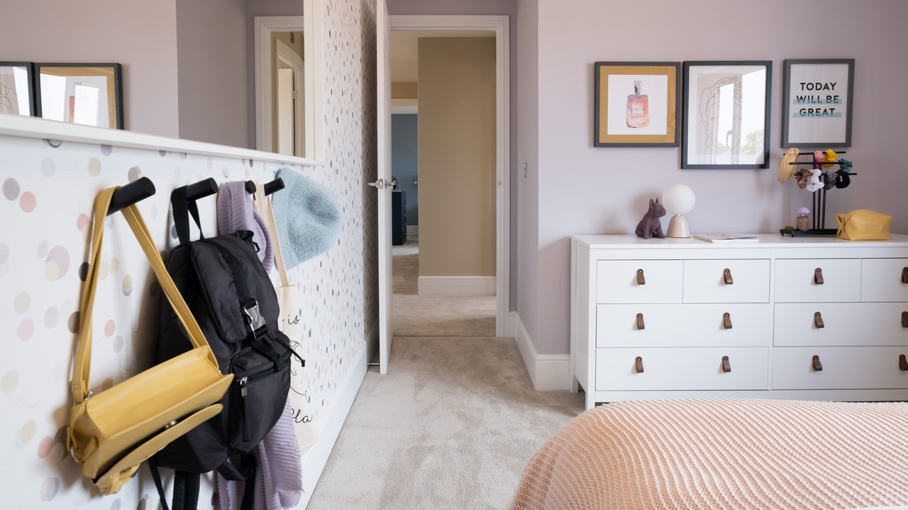  Pink child's bedroom with storage and coat hooks