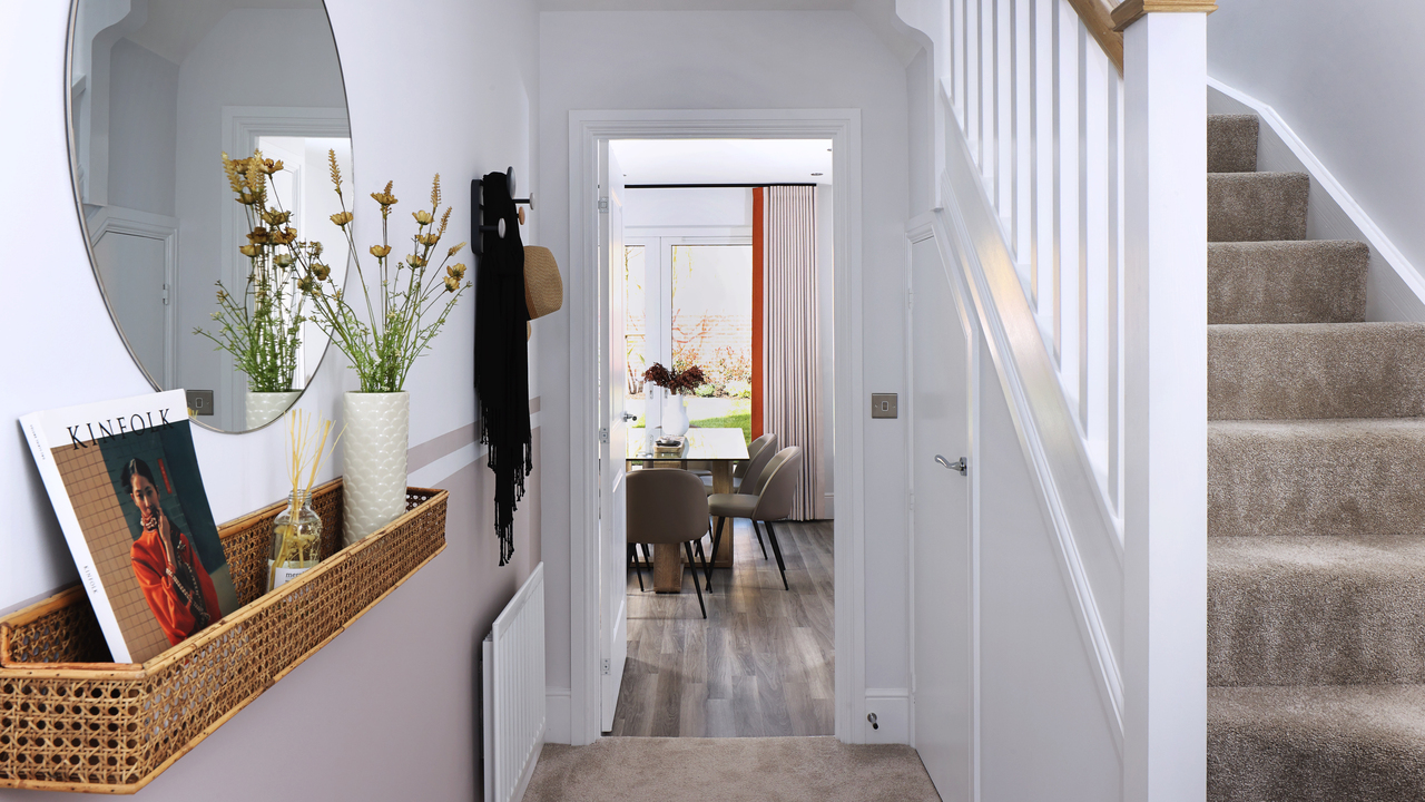 Hallway with large round mirror and rattan shelf leading through to the dining area