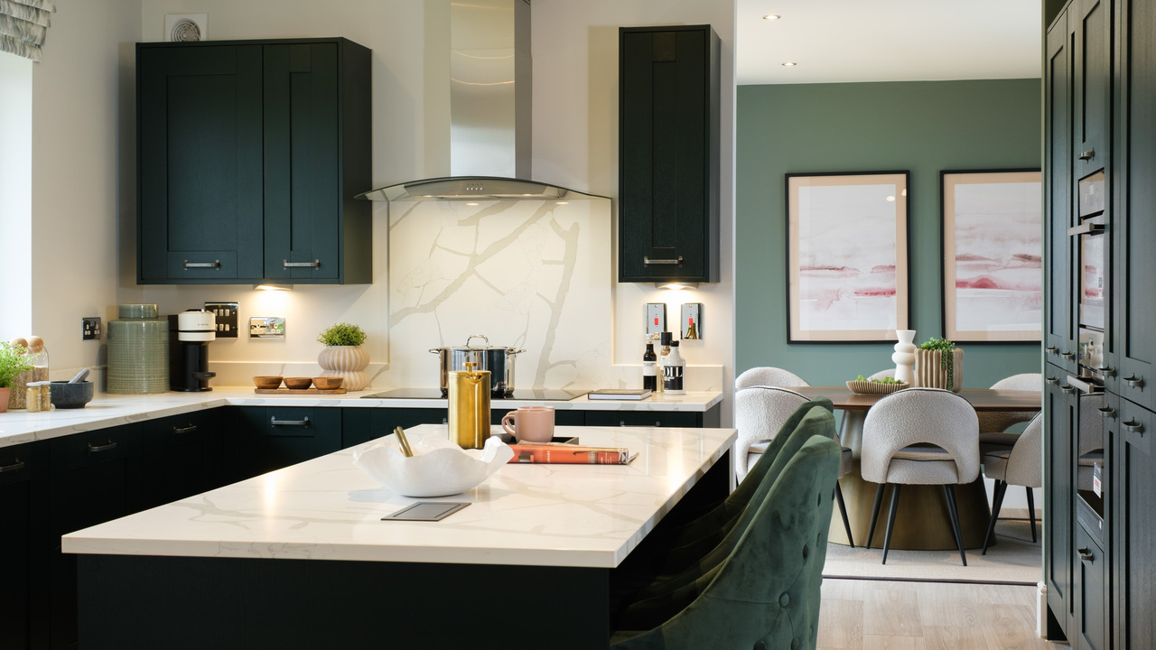 Kitchen with navy units and marble-topped island with dining area visible in the background