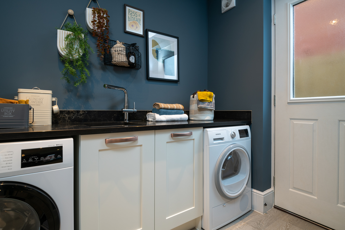 Utility room with dark walls and white units