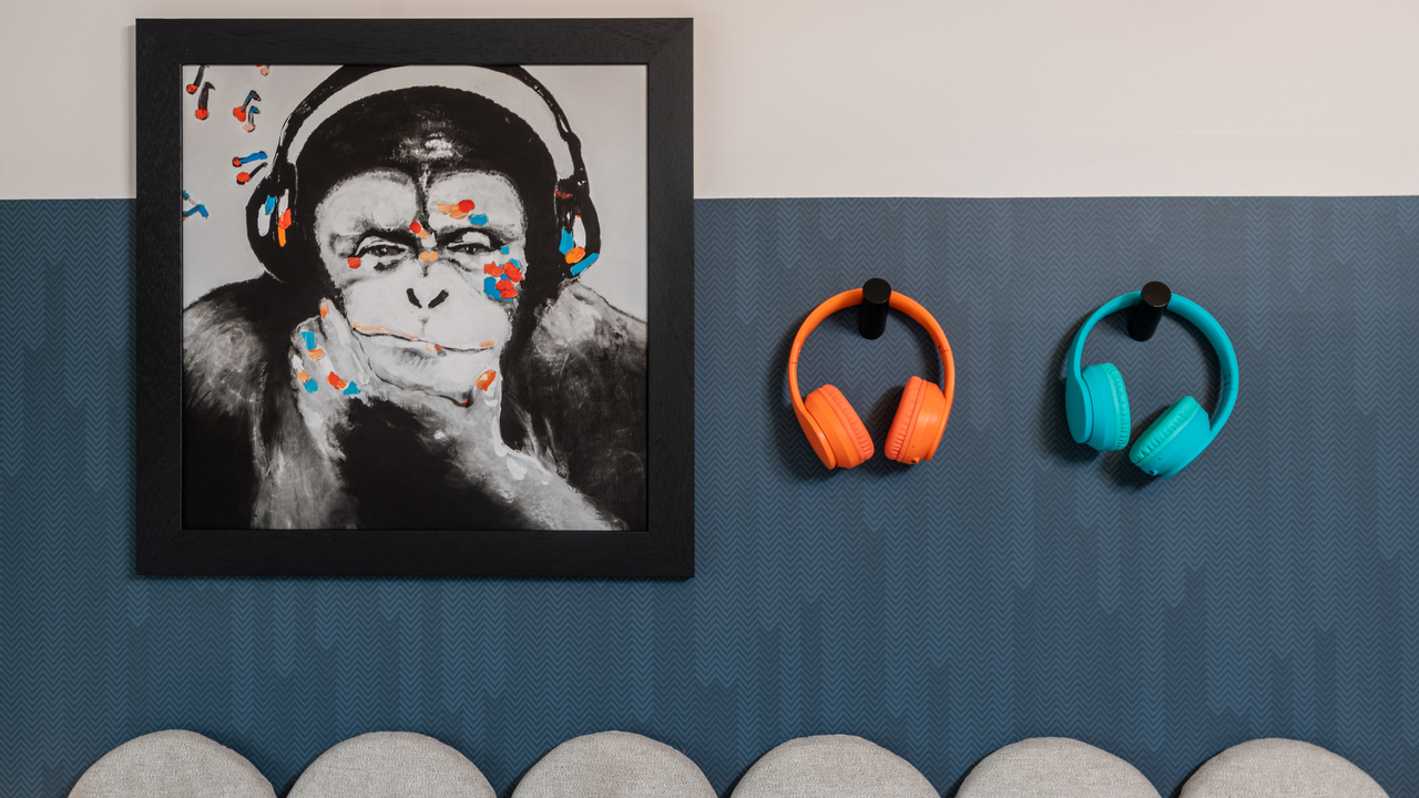 Artwork of monkey wearing headphones and 2 pairs of headphones on the wall