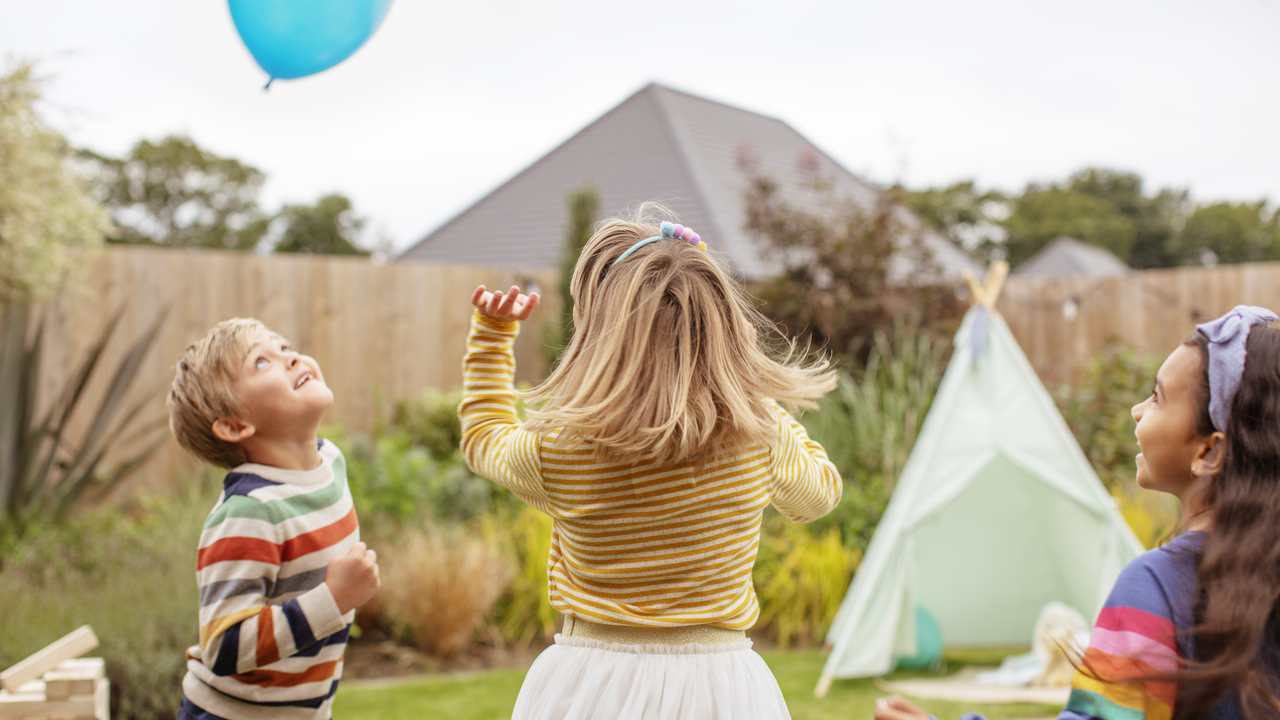 Children playing with balloon outside in the garden