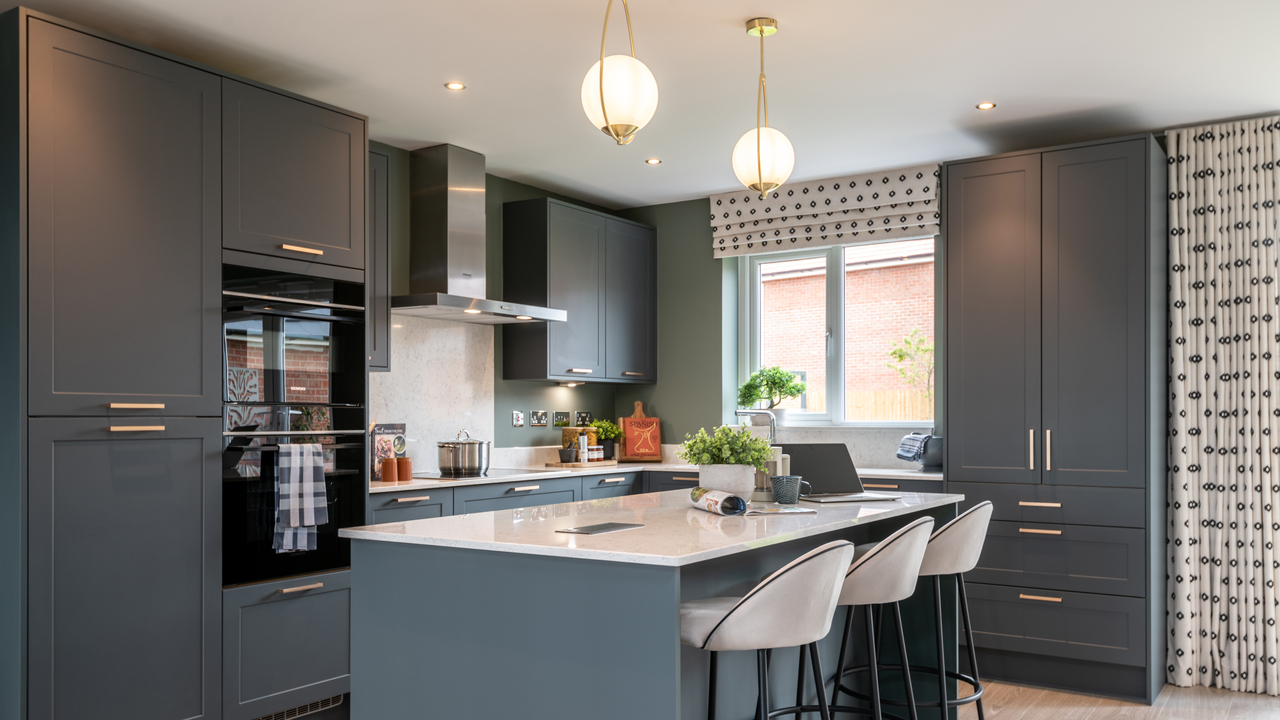 Indigo blue kitchen featuring two pendant lights hanging over a breakfast bar