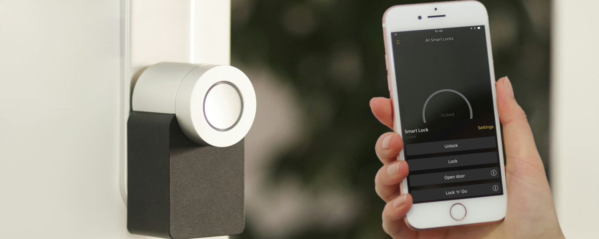 A woman holding a smart phone connected to her house front door lock.