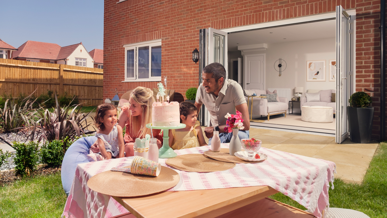 Family eating cake at a table in their garden