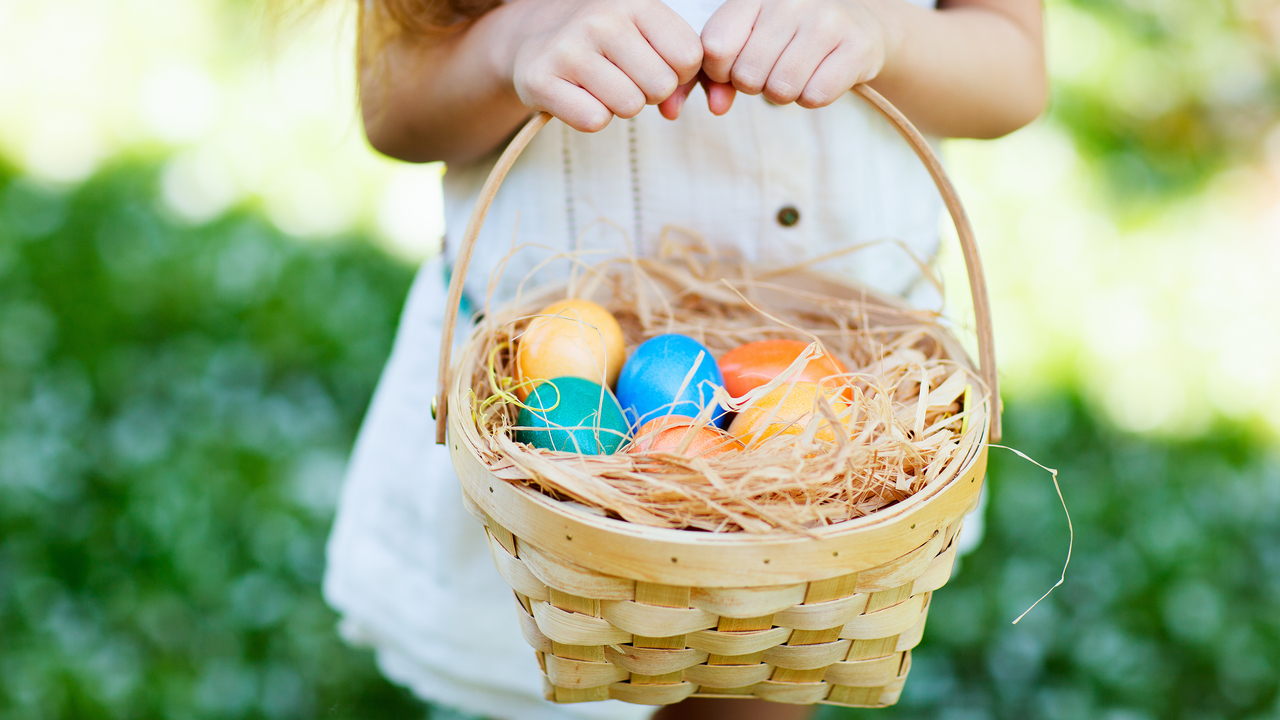Girl holding basket full of Easter eggs