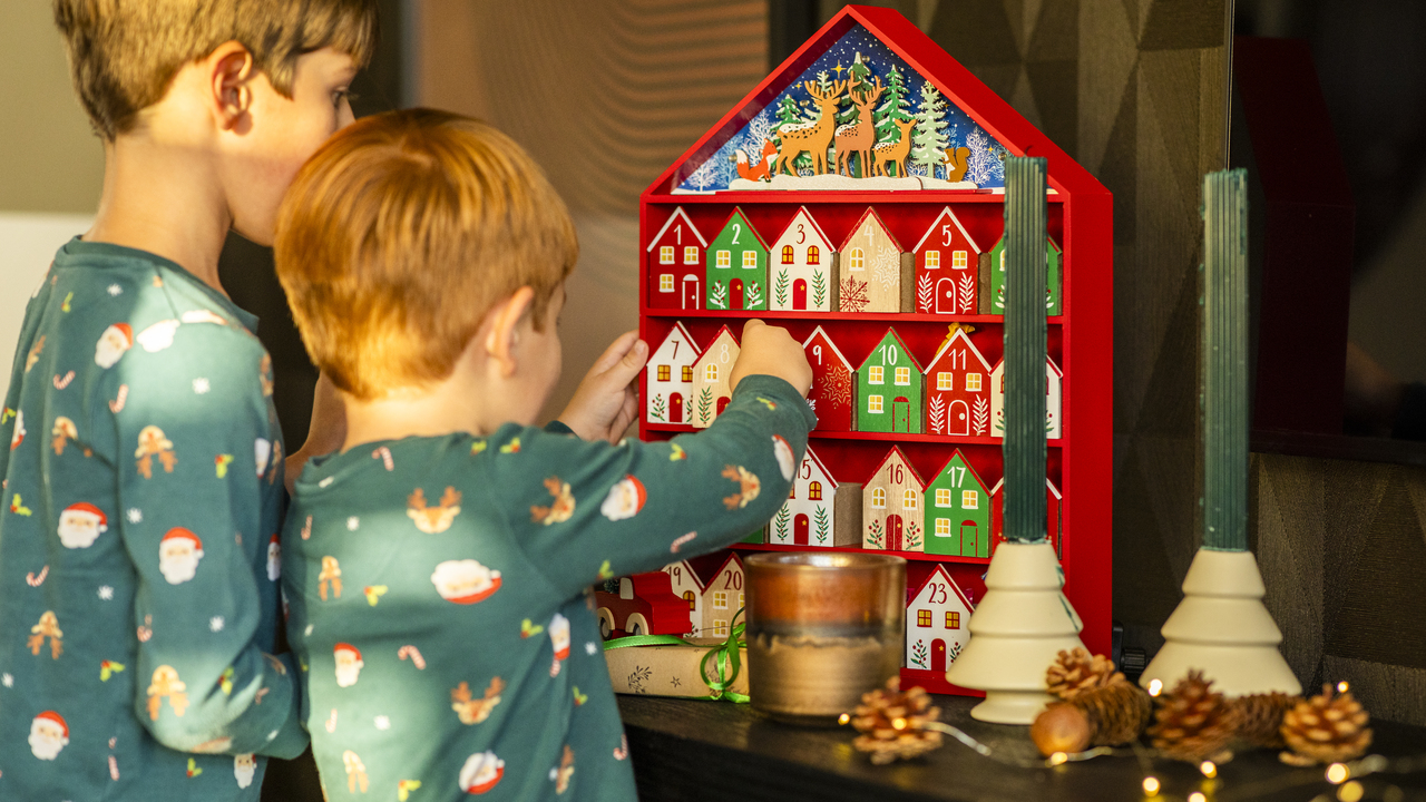 Two boys opening up wooden advent calendar