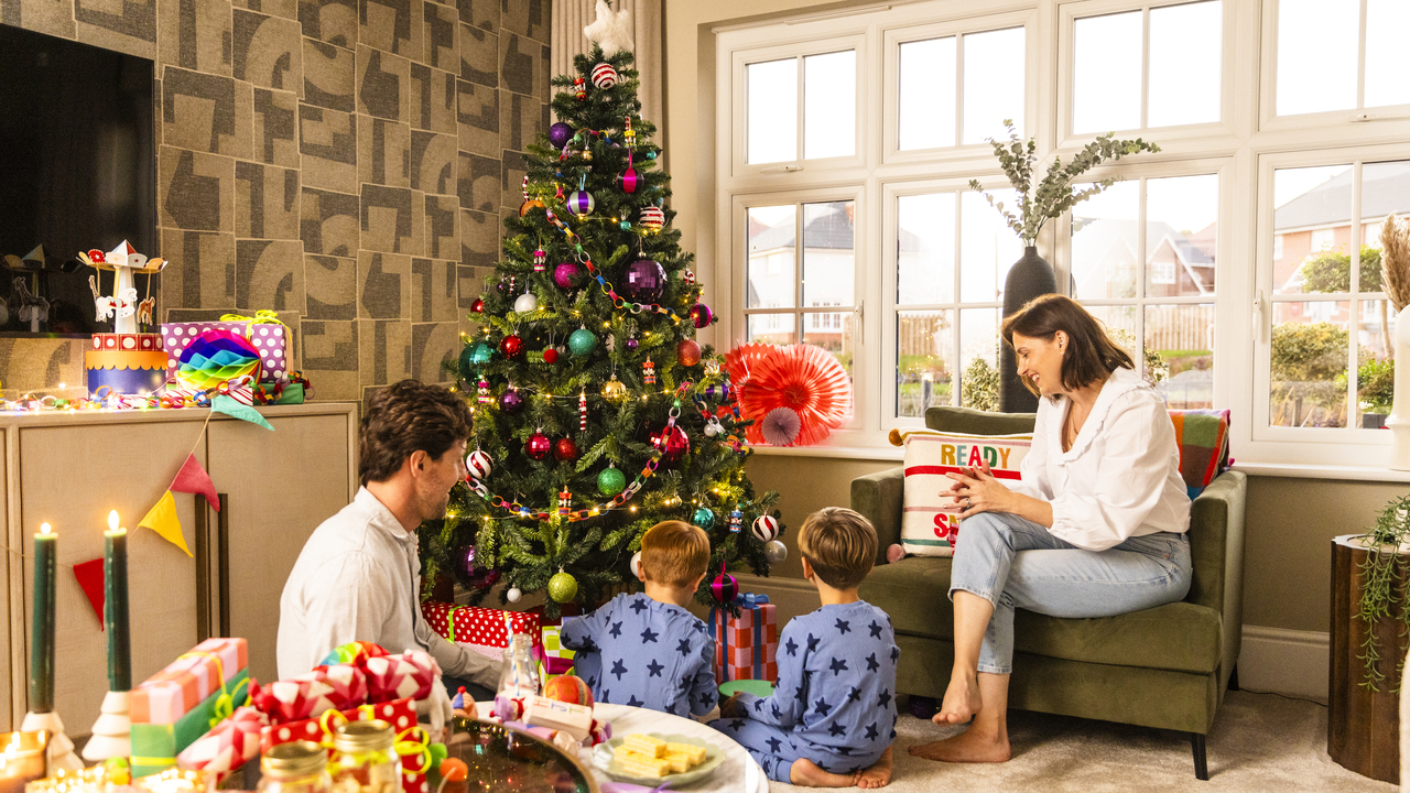Family sat around a Christmas tree with colourful baubles