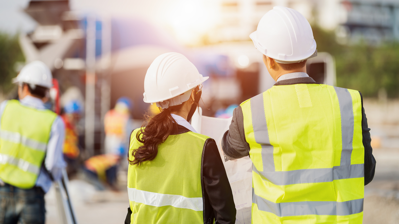 Two construction workers looking at paper plans