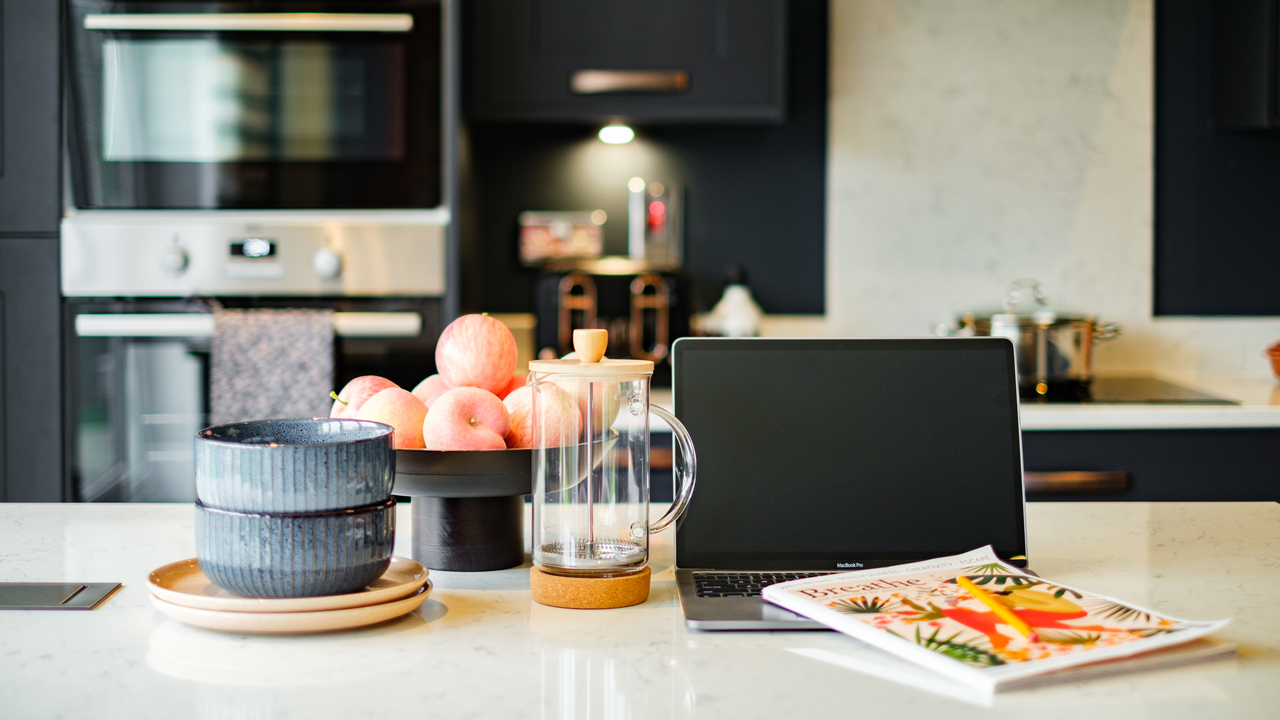 Laptop and coffee on the breakfast bar in a stylish kitchen