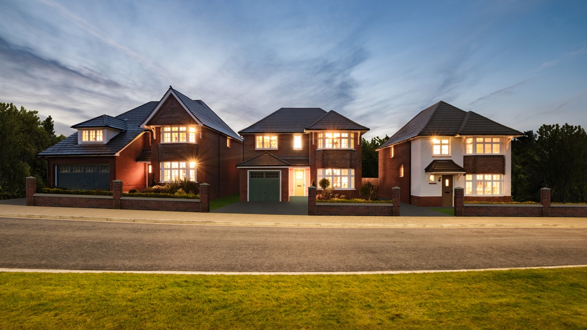 Redrow homes at night with the lights switched on inside so all the windows are glowing 