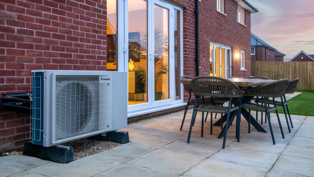 Air Source Heat Pump in the garden next to an outdoor table and chairs