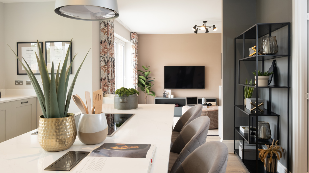 Kitchen with marble-topped breakfast bar leading through to the family living area