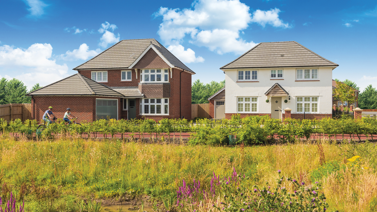 Two Redrow houses next to a cycle path and meadow