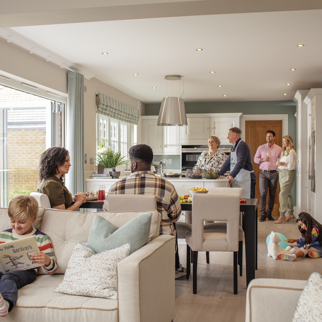 Couples in kitchen talking with children reading book and playing with toys